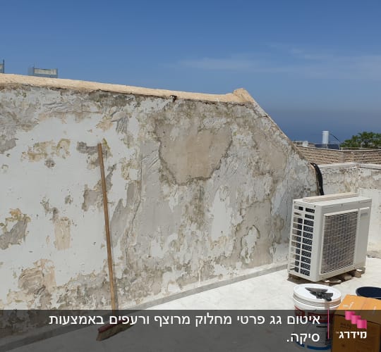 קיר מתקלף עם דלי צבע ומטאטא על הגג